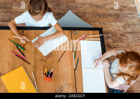 top view of cute kids drawing on papers Stock Photo