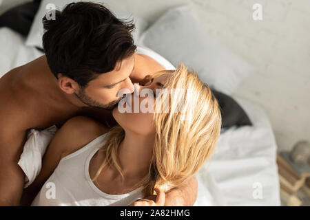 beautiful happy couple kissing in bed in the morning Stock Photo