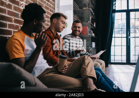 young multicutural businessmen sitting on sofa and discussing business ideas Stock Photo