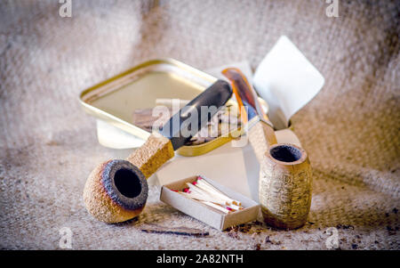 corncob pipe and fumed rim meerschaum on rustic backdrop Stock Photo