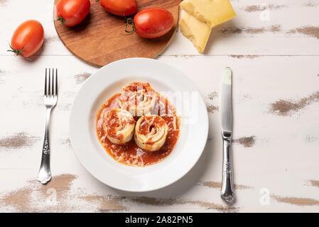 Traditional Italian Rondelli pasta with tomato sauce on rustic white wooden table background, soft light Stock Photo