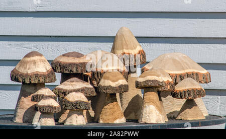 cute carved wooden mushrooms are made with a chain saw, and perfect for an outdoor garden Stock Photo