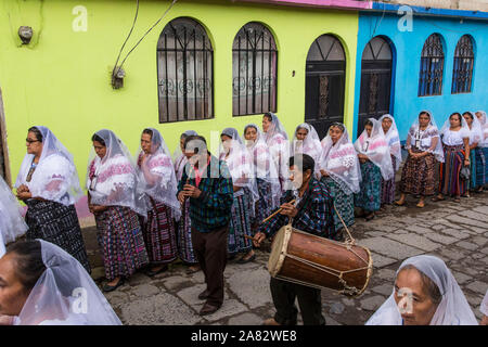 Catholic procession of the Virgin of Carmen in San Pedro la Laguna, Guatemala with a traditional flute player and drummer.  Women in traditional Mayan Stock Photo