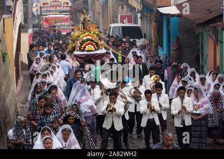 A band plays in the Catholic procession of the Virgin of Carmen in San Pedro la Laguna, Guatemala.  Women in traditional Mayan dress with white mantil Stock Photo