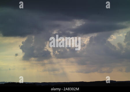 Bad weather front, thunderstorm over Upper Bavaria, storm, heavy rain and black clouds over silhouette of forest, Bavaria, Germany Stock Photo