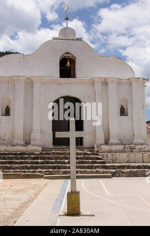 A small, simple Catholic church in Santa Cruz la Laguna, Guatemala with a cross on the plaza or town square in front. Stock Photo
