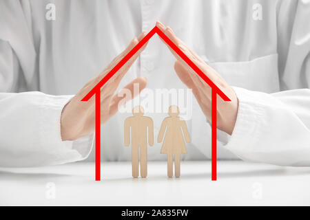 Female doctor with human figures on table, closeup. Health insurance concept Stock Photo