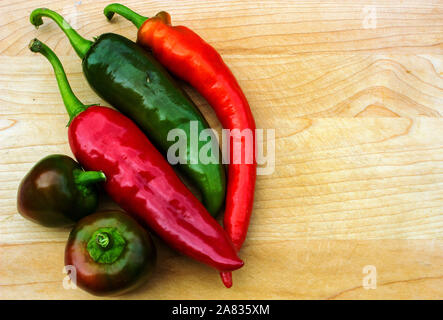 Variety of fresh peppers isolated on wooden table with copy space Stock Photo
