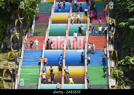 Tourists climbing a colourful stairs leading to the Batu Caves. Stock Photo