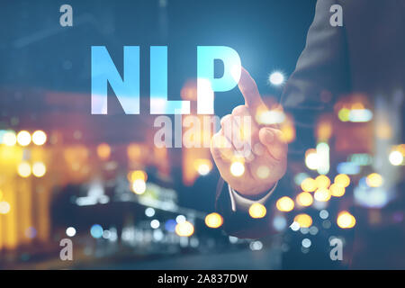 Double exposure of young businessman touching word NLP on virtual screen and illuminated city at night Stock Photo
