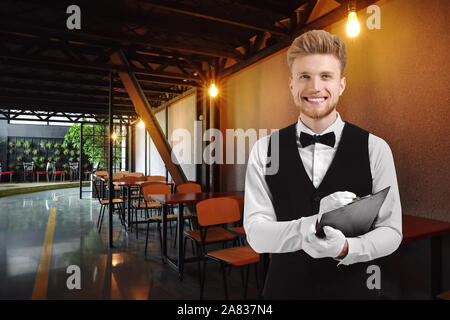 Handsome waiter in modern cafe Stock Photo