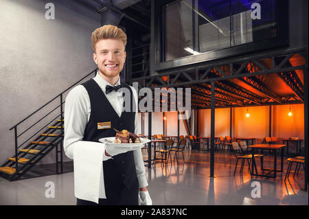 Handsome waiter with dessert in modern cafe Stock Photo