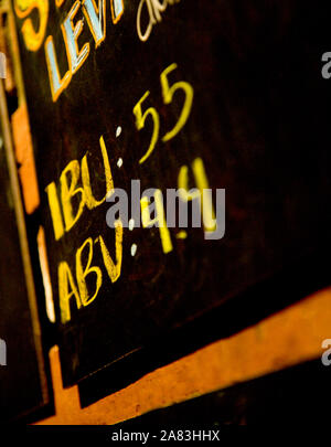 Close up of Chalkboard sign in restaurant with IBU and ABV information for beers. Stock Photo