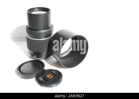 SLR telephoto lens and accessories - lens hood, cap on a white background. Stock Photo