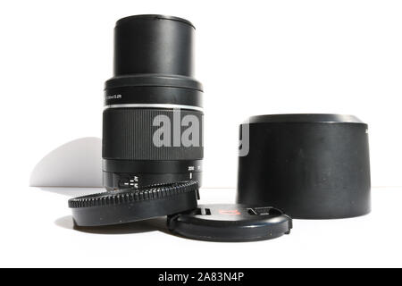 SLR telephoto lens and accessories - lens hood, cap on a white background. Stock Photo