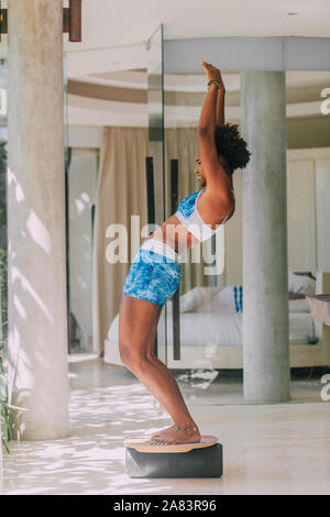 African American Woman Doing Abs Exercise With Leg Raise Studio