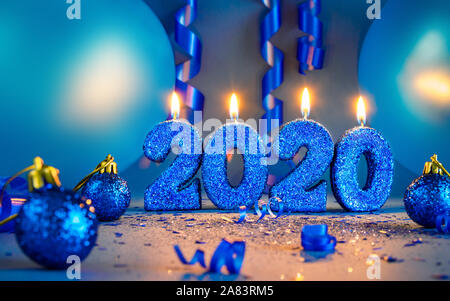 New years 2020 blue glitter candals with balloons and streamers - seasonal and holidays concept image. Stock Photo