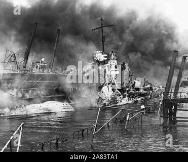 Naval photograph documenting the Japanese attack on Pearl Harbor, Hawaii which initiated US participation in World War II. Navy's caption: The twisted remains of the destroyer USS SHAW burning in floating drydock at Pearl Harbor Stock Photo