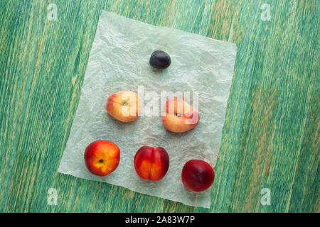 Donut Peaches also known as Saturn peaches, plum and nectarine on a rustic background. Healthy food concept. Stock Photo
