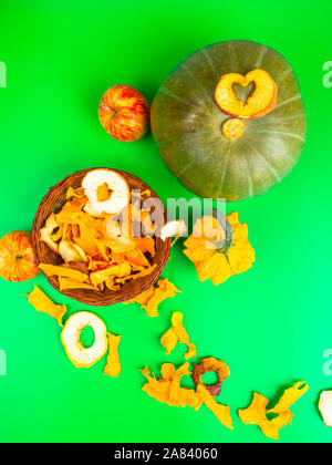 Dried fruits and vegetables slices apple, pumpkin in brown wicker basket on green background. Selective focus. Stock Photo