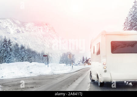 Winter mountain road landscape with campervan turning aside. Family vacation travel, holiday trip in motorhome. Beautiful austrian nature scene Stock Photo