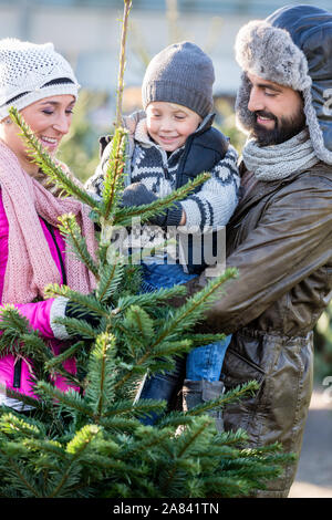 Family buying Christmas tree on market Stock Photo