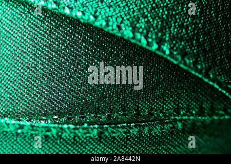 Abstract texture background of macro photographed shimmering green holiday fabric ribbon Stock Photo