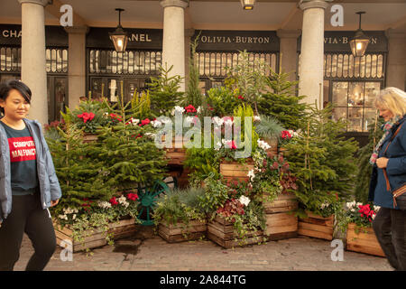 People walking near the Christmas decorations of Covent Garden, London, UK Stock Photo
