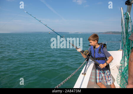 Premium Photo  Active man and teenage boy with rods fishing by lake on  summer day