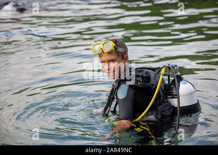 A young boy wearing full scuba diving outfit in the water. Stock Photo