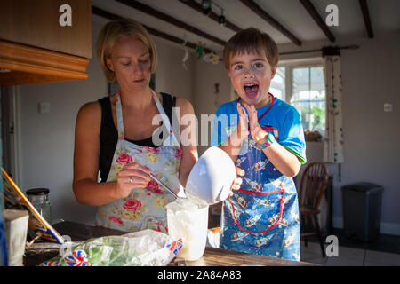 A mother and her son doing some home baking in the kitchen at home. Stock Photo