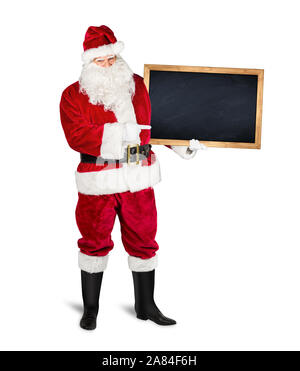 classic traditional red santa claus holding empty wooden slate blackboard chalkboark pointing with finger on it. blank slate with copy space isolated Stock Photo