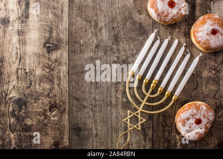Jewish Hanukkah menorah and sufganiyot donuts on wooden table. Top view. Copy space Stock Photo