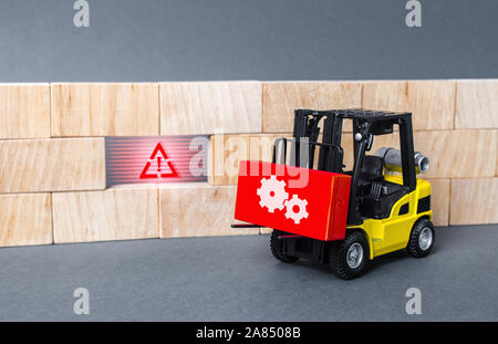 A forklift truck brings a red block to a void in the wall. Repair work, elimination of gaps. Improving system security, fixing errors and bugs. Integr Stock Photo