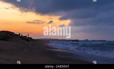 Fishermen catch fish on the seashore at sunset Stock Photo