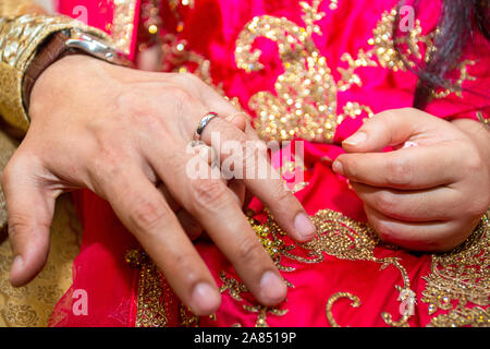 Groom places the wedding ring on the Bride’s finger at Bangladesh. Close up image. Stock Photo