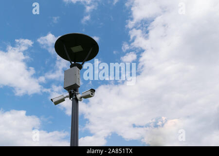 security surveillance cameras mounted on street light pole with copy space Stock Photo