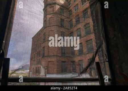 view through window of derelict mill building showing part of exterior structure Stock Photo