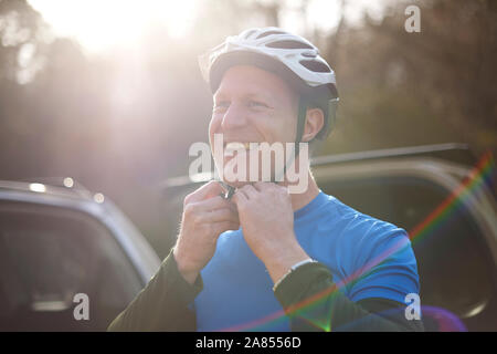 Portrait smiling man fastening bike helmet Stock Photo