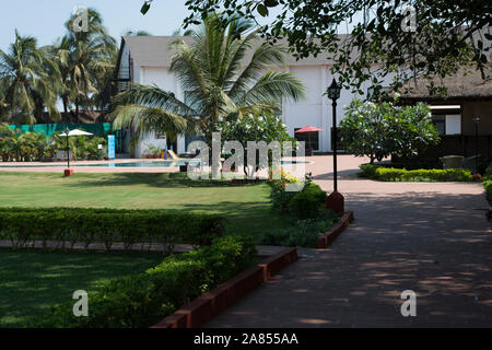 Swimming pool, garden and restaurant at upscale luxury hotel resort. La Calypso, Baga beach, Goa, India Stock Photo