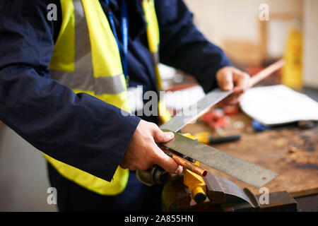 Close up young male student using ruler in shop class workshop Stock Photo