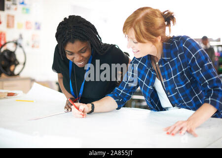 Female fashion designers drawing sewing pattern in studio Stock Photo