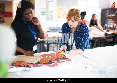 Female artists looking at screen print in art studio Stock Photo
