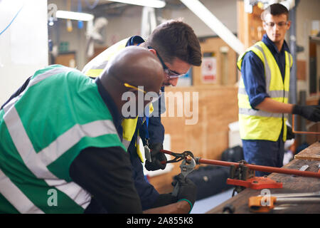 Male instructor helping students in shop class workshop Stock Photo