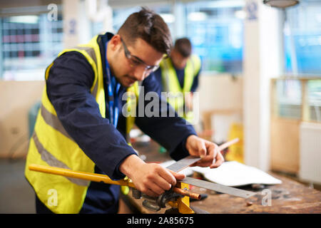 Male student using carpenter rule in shop class workshop Stock Photo
