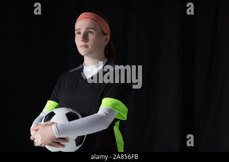 Portrait confident, ambitious teenage girl soccer player holding ball Stock Photo