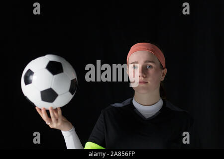 Portrait confident, determined teenage girl soccer player holding soccer ball Stock Photo
