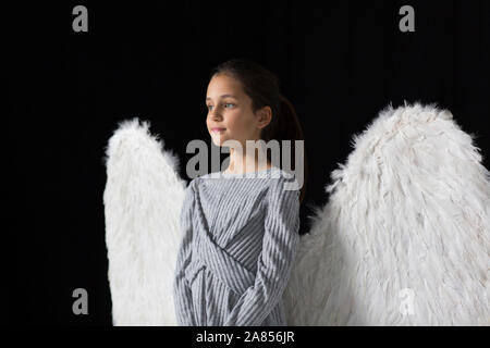 Serene girl wearing angel wings Stock Photo