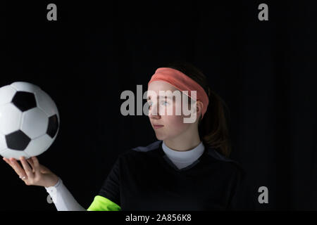 Focused teenage girl soccer player holding ball Stock Photo