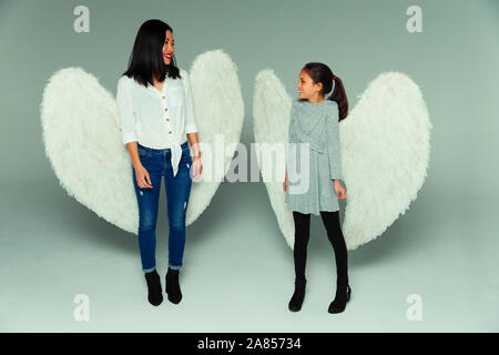 Happy mother and daughter wearing angel wings Stock Photo